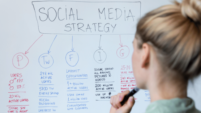 female ponders social media strategy on white board