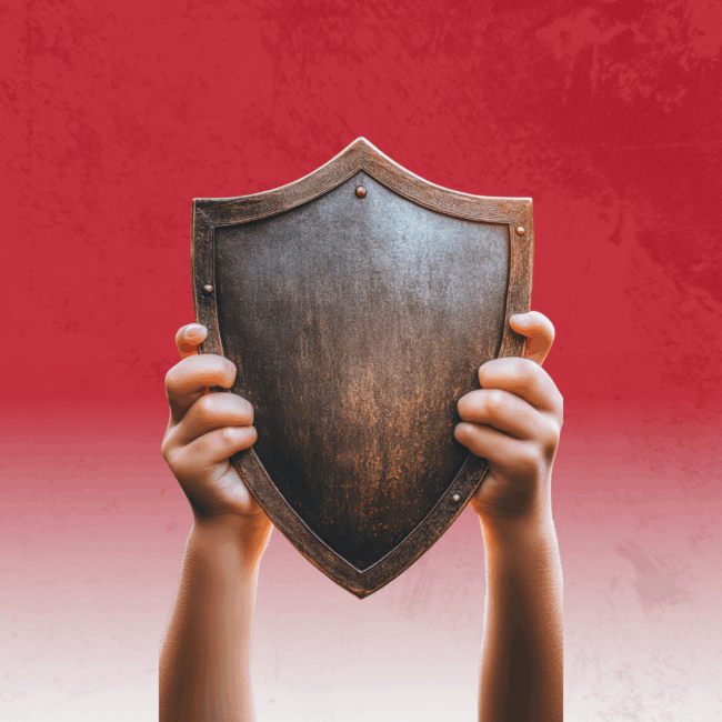 Child's hands holding up a wooden shield over a red background